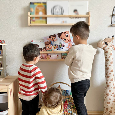 Drei Kinder lesen ihr neues personalisiertes Geschwisterbuch von Hurra Helden, das den Titel „Ein Dreamteam“ trägt.