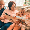 Glückliche Enkelkinder und Großeltern mit ihrem personalisierten Buch für Omas und Opas. 
