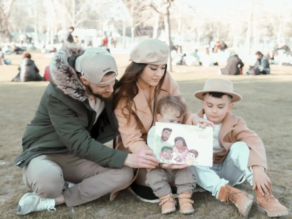 Eine Familie im Park zeigt ihr personalisiertes Buch für Familien mit 2 Kindern von Hurra Helden. 