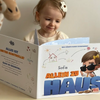 Ein kleines Mädchen schaut sich ihr neues personalisiertes „Allein zu Haus“-Buch an.