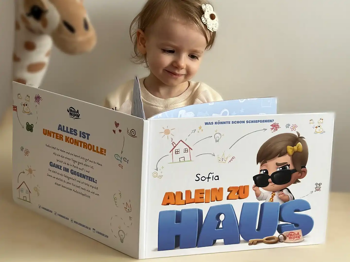 Ein kleines Mädchen schaut sich ihr neues personalisiertes „Allein zu Haus“-Buch an.