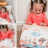 Ein zweijähriges Mädchen mit ihrem neuen personalisierten Geburtstagsbuch.