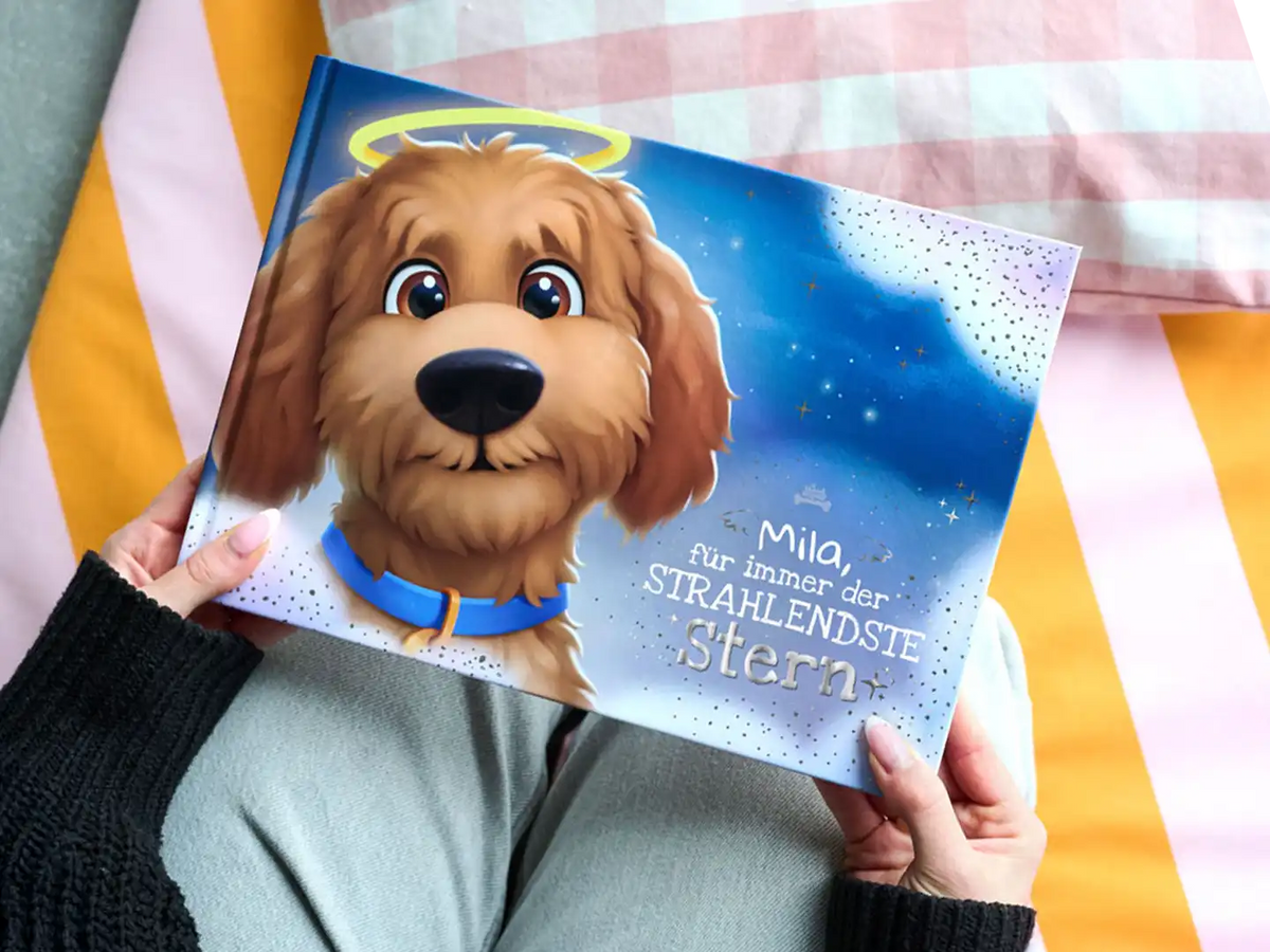 Nahaufnahme eines personalisierten Premium-Erinnerungsbuchs für Hunde mit dem Titel „Mila, für immer der STRAHLENDSTE Stern“, das einen gezeichneten Hund mit Heiligenschein auf dem Cover zeigt – ein einzigartiges Andenken für trauernde Hundebesitzer.